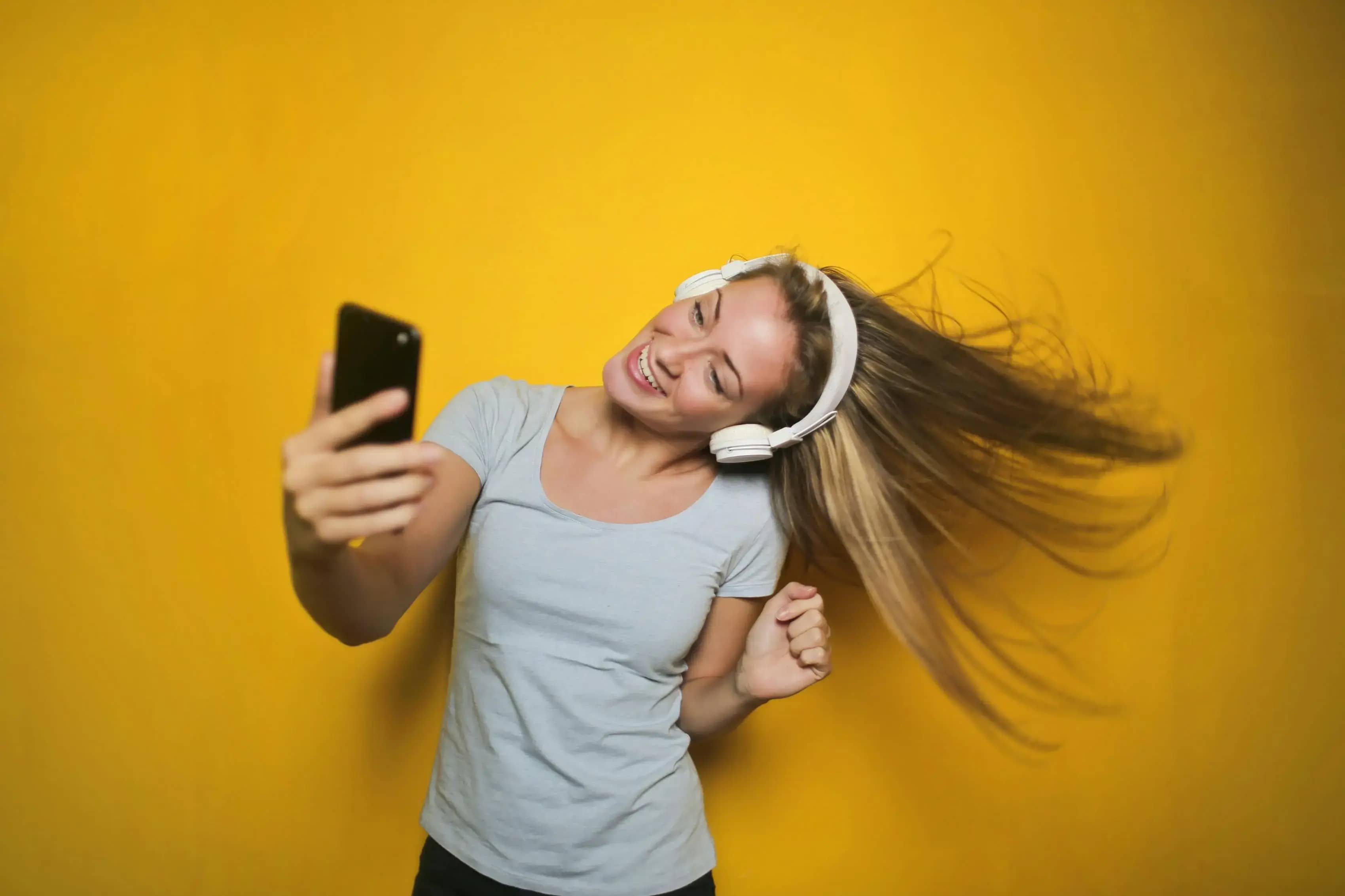 Girl excitedly using the Taskli Home Service app with a yellow background